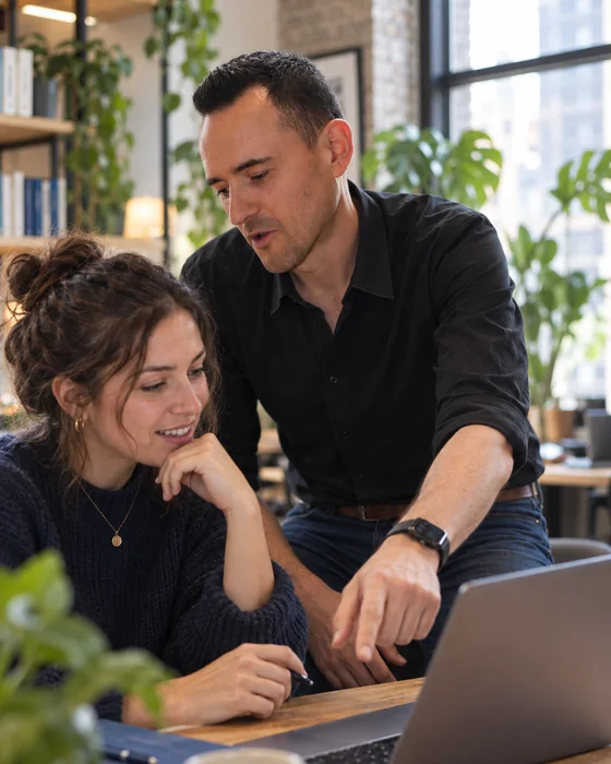 Julien guides a client at her laptop.