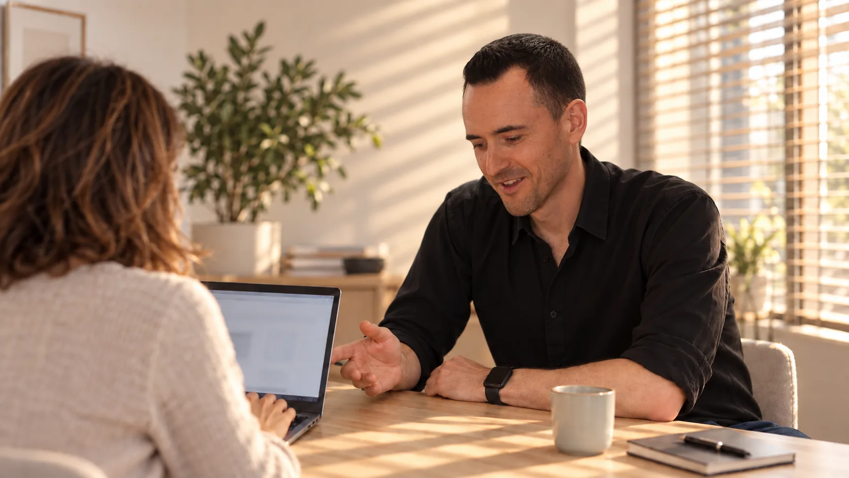Julien assis à côté d'une entrepreneure vue de dos, ses mains sur son clavier.