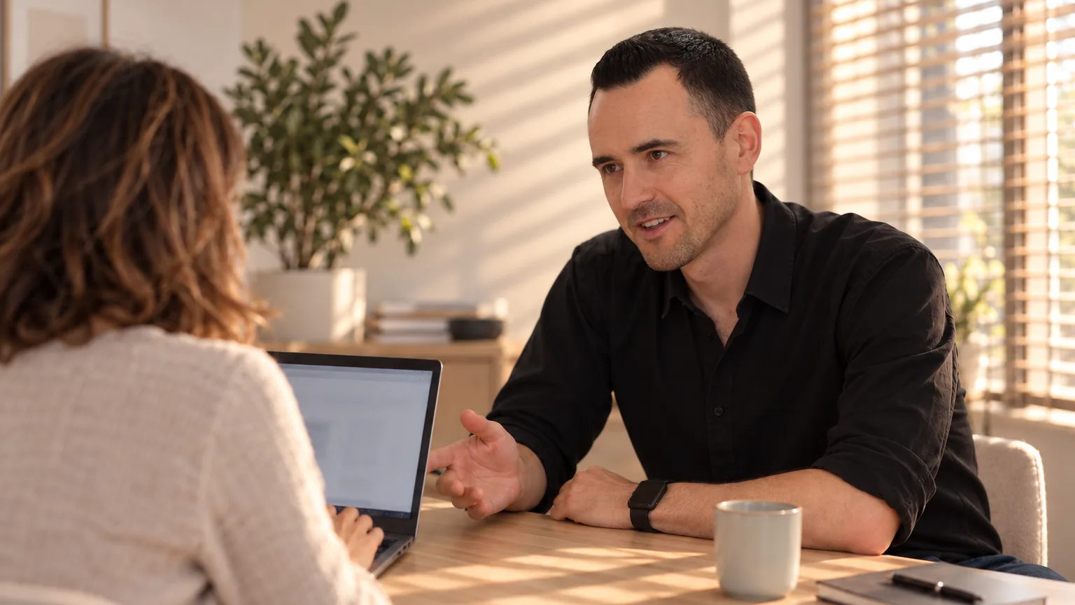 Julien assis à côté d'une entrepreneure vue de dos, ses mains sur son clavier.